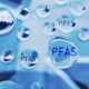 Illustration of PFAS &ldquo;forever chemicals&rdquo; represented as transparent water droplets labeled PFAS, symbolizing contamination in drinking water.
